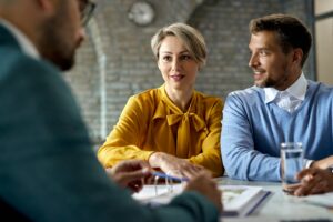 Smiling couple having consultations with their financial advisor in the office.
